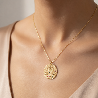 Złoty naszyjnik z rustykalnym medalionem zodiaku i kolorowymi kamieniami.