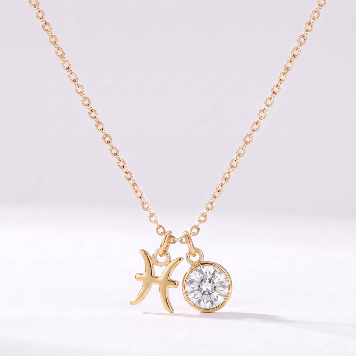 Złoty naszyjnik ze znakiem zodiaku Ryb i cyrkonią.