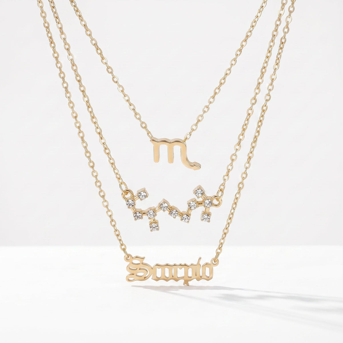 Zestaw 3 złotych naszyjników ze znakiem zodiaku Skorpiona.
