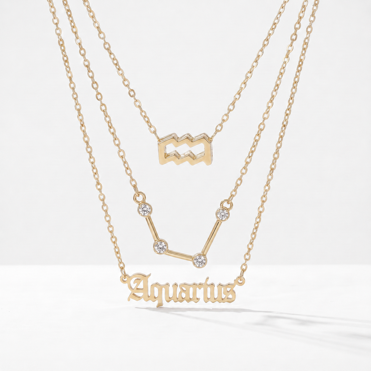 Zestaw 3 złotych naszyjników ze znakiem zodiaku Wodnika.
