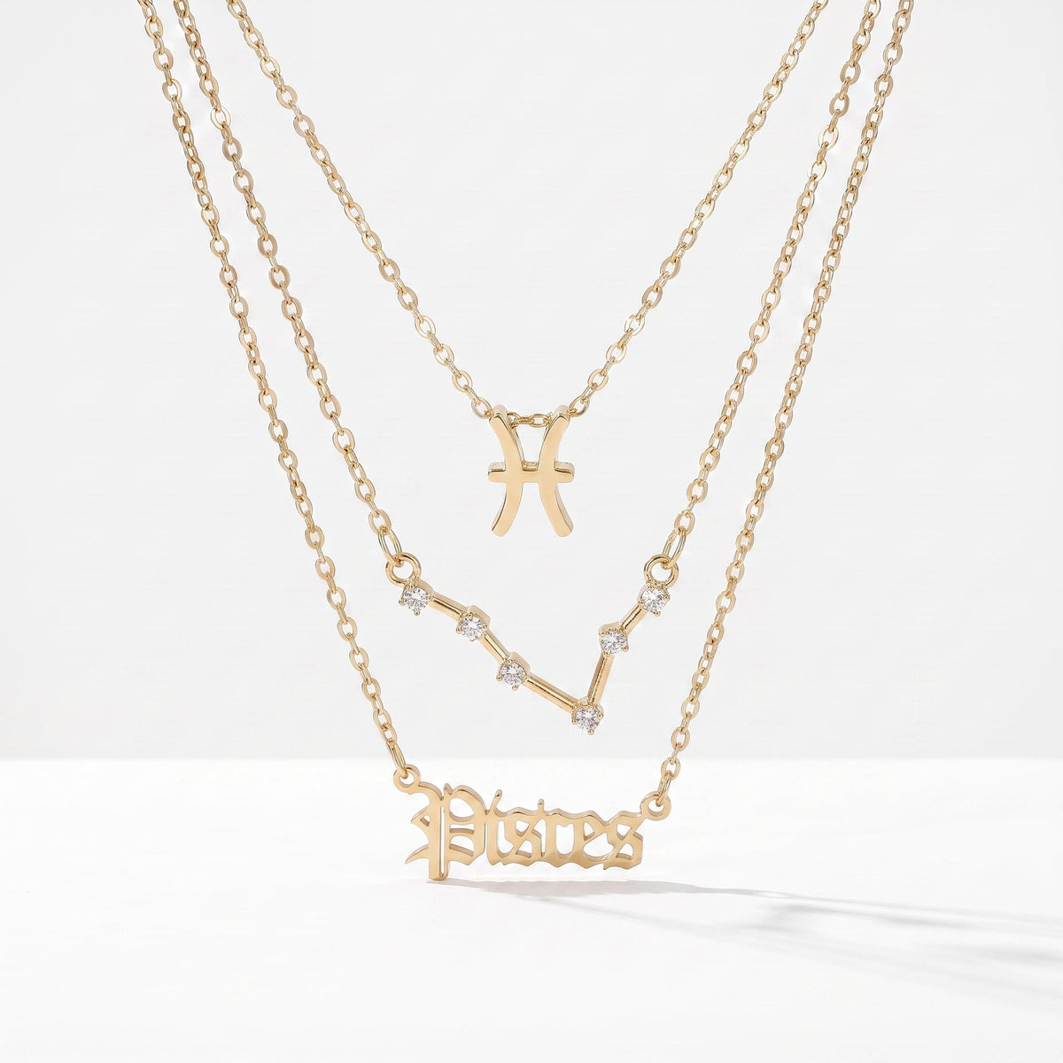 Zestaw 3 złotych naszyjników ze znakiem zodiaku Ryb.